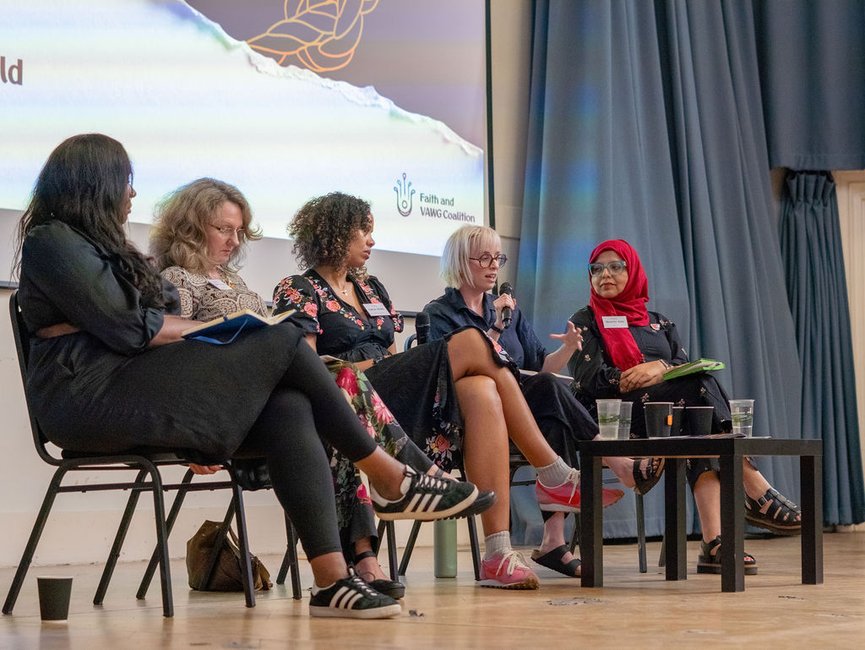 A panel of five women on a stage